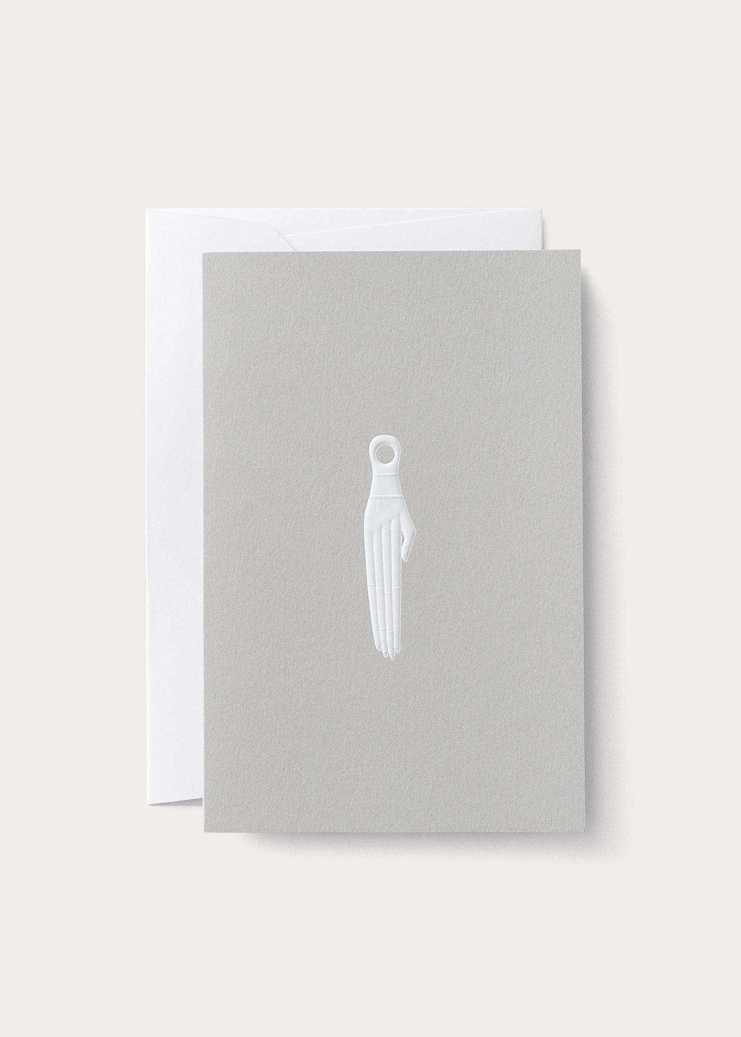 A greeting card with embossed geometric design and a figure resembling a deity, placed on a white background.