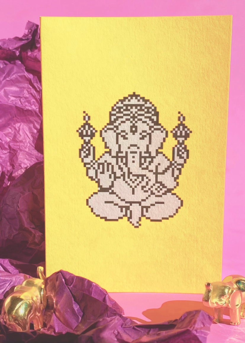 Yellow card with a Ganesha illustration on a pink background with golden elephants and purple tissue paper